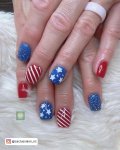 Short Nails With Red And White Stripes And Blue And White Star Designs.