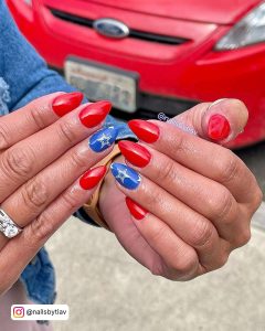 Red Almond Nails With A Blue Feature Nail With Silver Stars