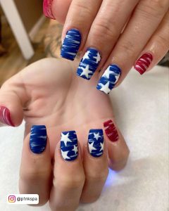 Blue Square Tip Nails With White Stars And A Red Feature Nail