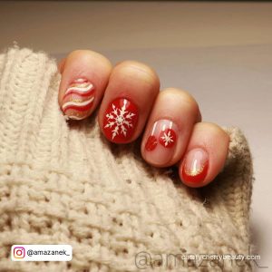 Cute Red And White Nails With Swirly White And Red Designs, Snowflakes, And French Tip Design