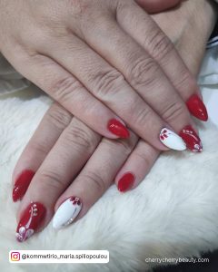 Flowery Almond Red And White Gel Nails On Fur Clothe