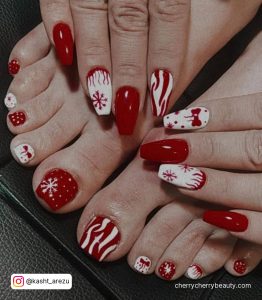Holiday Red And White Toe Nail Designs On Black Surface