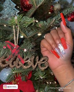 Long Addie Winter Red White And Silvery Coffin Nails With Glitters, Diamonds,And Snowflakes Design In Front Of A Christmass Tree