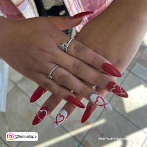 Long Almond Red White Nails With Love Inscription With Cream Tile Background
