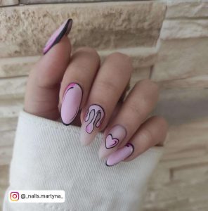 Matte Pink And Matte Nude Almond Nails With Black Outline Cartoon Designs