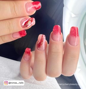 Ombre Red And White Marble Nails With Gold Glitter Beside Ring Light