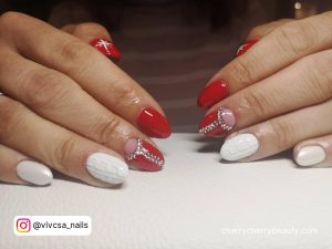 Short Almond White Red Nail Design With Snowflakes And Rhinestones On A White Surface