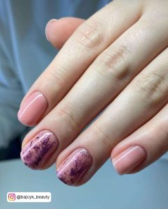 Short Light Pink Nails With Purple Glitter On Two Finger Nails