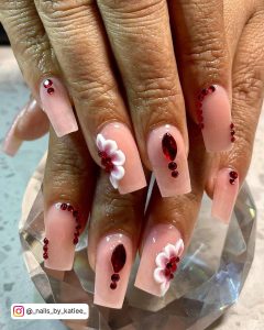 Short Nude Ballerina Nails With Red Gems And Flower Designs