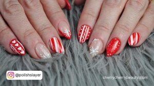 Short Red And White Stiletto Nails With Stripes And Snoflakes On Grey Fur