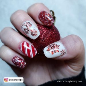 Short White And Red Nails With Glitters And Winter Designs Holding Chritsmas Decorations
