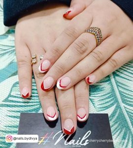 Simple Red And White French Tip Nails On Leaf-Designed Surface