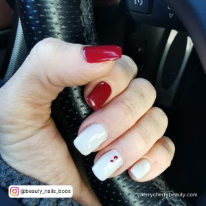 Simple Red And White Nail Idea Holding A Black Steering Wheel