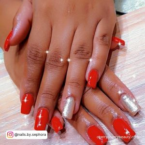 Simple Red And White Nails With Glitters On Wooden Surface