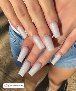A Girl Showing Her Ombre Nails White With Glitter At The Beach