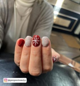 A Girl With Cropped Face Showing Red And White Glitter Nails Painted For Christmas