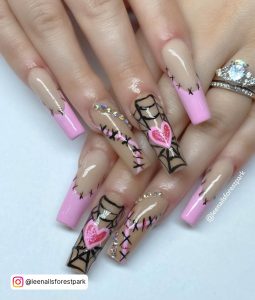 Baddie Pink, Black, And White Nail Design With Rhinestones, Stitch Design, And Pink Heart, Laying On White Surface