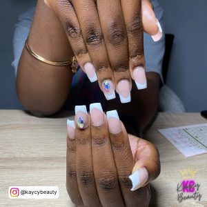 Baddie White French Tip Nails With Diamonds On A Wooden Table