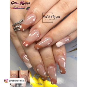 Beautiful Brown And White Acrylic Nails With French Tips And White Star Design Over White Surface