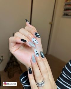 Black And White Almond Nails With Silver Glitter Feature Nail And Snowflake Designs