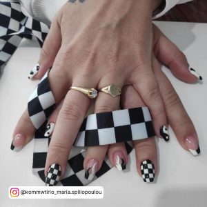 Black And White Chess Nails With Monochrome Fiery Design, French Tips, And Yin And Yang Design, Wrapped Around Checkered Clthe.