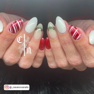 Christmas Red And White Glitter Nails With Leaves Designing On Index Finger