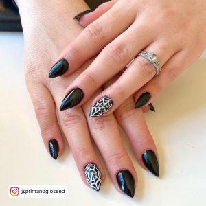 Classy Halloween Nails Black And White With Spider Web Design Laying On White Surface.