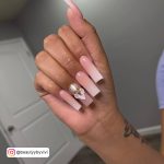 Classy Long Pink And White Ombré Nails With Flower Design And Rhinestones And White Door In Background
