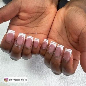 Classy Nude Nails With White Tips With Shimmmery Line Work On White Surface