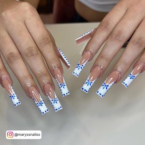 Claw Blue And White French Tip Nails With Star Design On Cream Surface