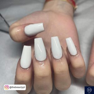 Coffin All-White Acrylic Nails On White Surface