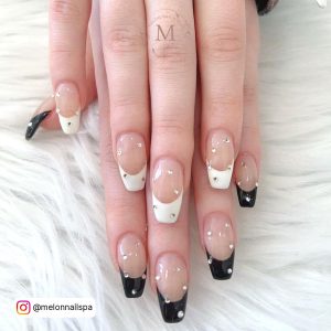 Coffin Black And White French Tips Nails With Diamonds On All Nails Laying On Fur