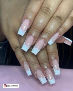 Coffin-Shaped Ombre White Tip Nails With Glitter Placed Over A Pink Shelf