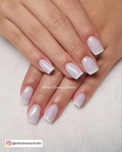 Comely White French Tip Nails With Glitter Over A White Table