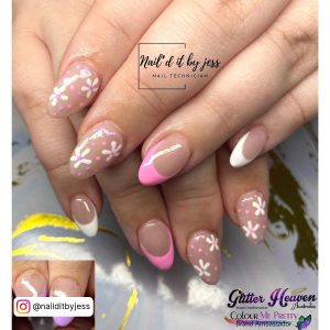 Cute Short Pink And White Acrylic Nail Design With Flowers And Pink And White French Tips Over Artsy White Surface.