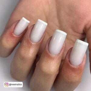 Elegant Acrylic Nails With White Tips Over White Surface