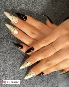 Glamorous Black And White Acrylic Nails With Thoirny Design Over Grey Towel