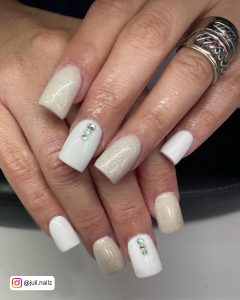 Glittery Short White Acrylic Nails With Diamonds Over White Surface