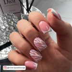 Hand With Pink And White Square Nails Infront Of Dior And Air Diffuser