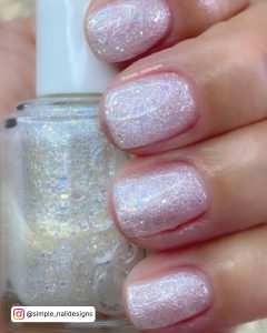 Hand With Rounded White Glitter Nails, Holding Nail Polish Bottle