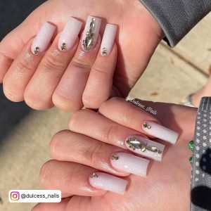 Hands With Beautiful Pearl White Nails With Glitter That Are Embellished With Silver Rhinestones.