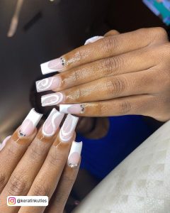 Hands With White Glitter Designed Nails Infront Of A Black Woman Face