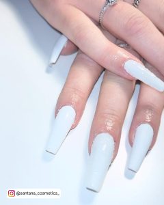 Long Coffin White Glitter Nails Placed Over A White Shelf