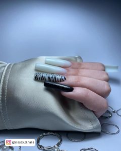 Long Milky White Square Tip Nails With Zebra Print Feature Nail And A Black Nail