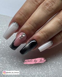 Milky White Coffin Nails With Silver Glitter On The Cuticles With A Black Glitter Feature Nail And A Black French Tip Nails With Rhinestones