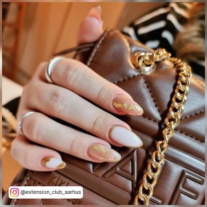 Milky White Oval Nails With Nude And Brown Marble Effect And Gold Foil
