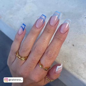 Modern Multiple-Tone Blue And White French Nails Over Stony Surface