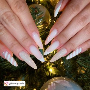 Nude Almond Nail With White Stripes, Nude Glitter Almond Nail, Nude And White French Tip Nail And Nude Almond Nail With White Snowflake Design