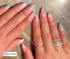 Ombre Milky White Gel Nails With Glitter Laying On Wooden Surface