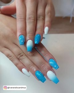 Ombre Sky Blue And White Nails With Heart And Plain White Polish Over A White Surface